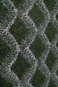 Gros plan sur la texture en tricot de laine épaisse avec motif à losanges vert foncé