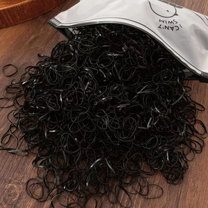 Black elastic hair ties for girls spilling from a frosted pouch with chick pattern
