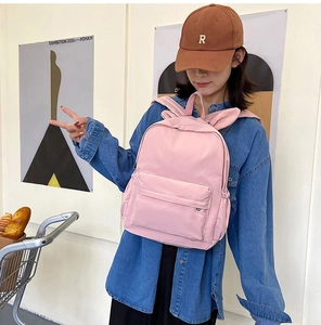 Detailed view of pink school backpack with cute bunny ears and spacious front pocket