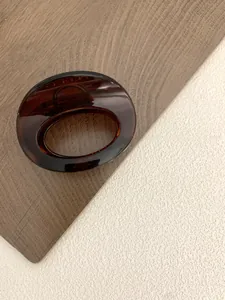 Detail view of oval tortoise shell resin hair claw clip with a glossy amber finish