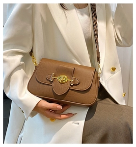 Détail du sac bandoulière en cuir marron avec fermoir doré et sangle géométrique