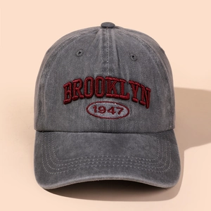 Close-up of red Brooklyn 1947 embroidery on a vintage grey washed cotton baseball cap