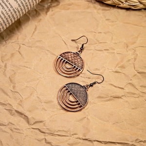 Detailed close-up of bohemian bronze geometric hoop earrings with hollow texture