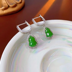 Detailed close-up of zircon gourd earring with green pear-shaped stone in silver setting