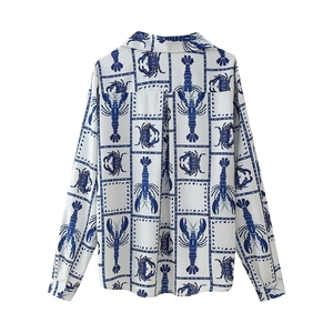 Detail of the back side of a white long-sleeved shirt with blue lobster and crab patterns