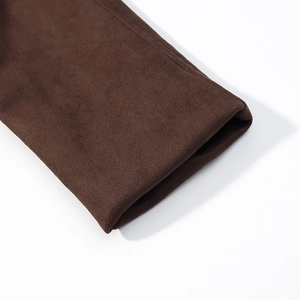 Détail macro du poignet de la veste en daim marron foncé montrant couture et texture