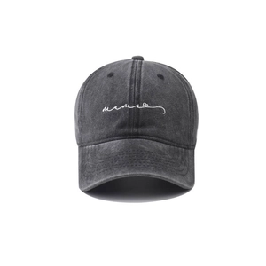 Close-up of white script embroidery on a dark grey washed vintage style baseball cap