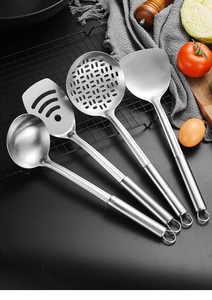 Detail of stainless steel kitchen utensil set including ladle and spatulas on a rack