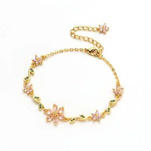 Macro detail of cherry blossom bracelet with pink zircon and golden leaf clasp