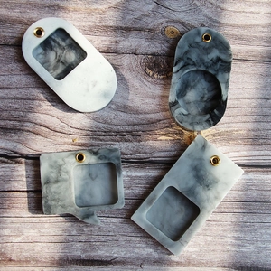 DIY silicone molds for pendants in various shapes on a rustic wood background