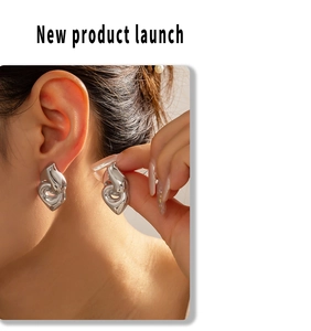 Close-up of geometric heart-shaped silver earrings worn by a model for a stylish look