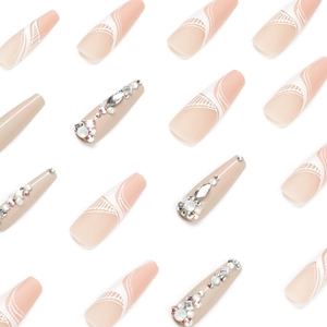 Long ballet press-on nails with nude pink base, white lace pattern and luxury rhinestones