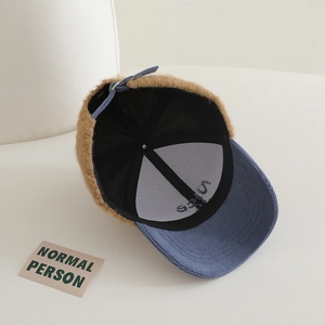 Detail of kids baseball cap featuring blue corduroy brim and brown faux fleece texture
