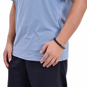 Men's natural black matte stone beaded bracelet with cross charm worn on wrist