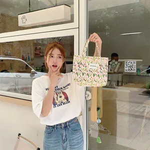 Détail du sac cabas en toile à fleurs tulipes avec étiquette tissée sur le devant