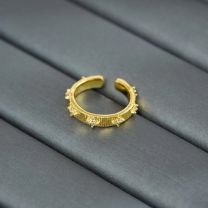 Macro view of adjustable vintage gold ring with bark texture and inlaid zircon stones