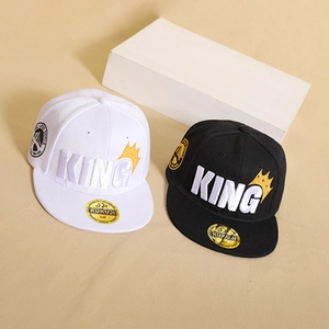 Dettaglio del ricamo KING e del motivo a corona sui cappellini hip hop snapback bianchi e neri