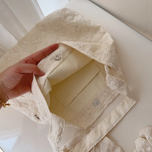 Detail of embroidered canvas tote with magnetic clasp and internal pocket showing inside