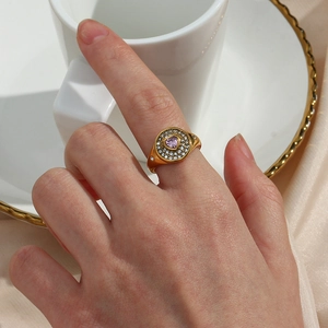 Detail of 18K gold-plated ring with a pink heart zircon and surrounding crystals
