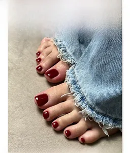 Close-up of deep red glossy press-on toenails on a natural foot, detail view of JP4259