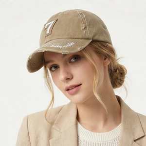 Close-up of khaki washed baseball cap with number 7 patch and distressed brim details