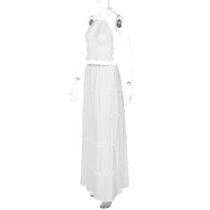 Detail of white two-piece set featuring halter crop top and tiered ruffle maxi skirt