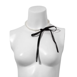 Vintage style choker necklace featuring white pearls and a large black velvet ribbon bow