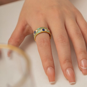 French vintage Evil Eye ring in gold with blue enamel on female finger closeup