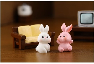 Miniature resin white and pink rabbits in a cozy micro landscape living room scene