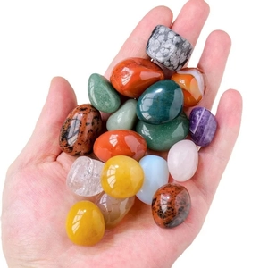 Hand holding polished natural mixed gemstone crystals for aromatherapy or decor