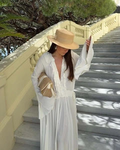 White V-neck pleated maxi dress with lace trim, styled with a straw bag and sun hat