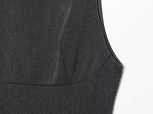 Close-up of high-quality dark grey woven fabric showing precise waist seam and dart details