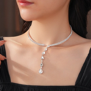 Macro view of a double-layered necklace featuring a sparkling teardrop zircon pendant