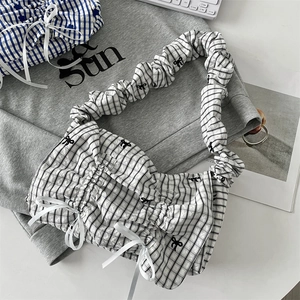 Detail of checkered tote bag with ribbon bow and gathered elastic shoulder strap