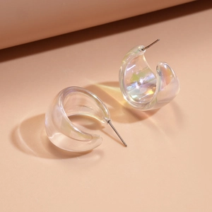 Detailed macro view of translucent C-shaped iridescent acrylic earrings with aurora finish