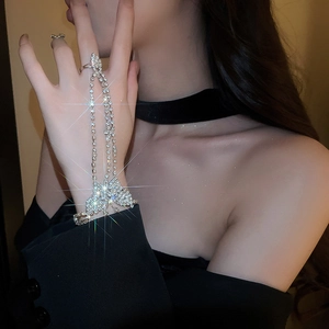 Close-up of a sparkling silver butterfly finger bracelet with rhinestones on a female hand