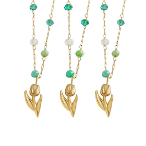 Three gold tulip pendant necklaces with green and white crystal beads on a white background