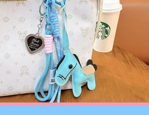 Detail view of cute dopamine leather pony bag charm with braided rope and heart photo frame.