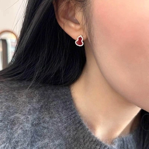 Red enamel and zircon wulu stud earrings with gold plating on a fashion model