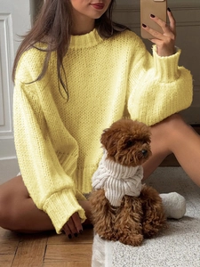 Women's yellow chunky knit sweater with high neck and relaxed fit in cozy home setting
