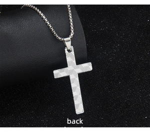 Macro shot of silver stainless steel cross pendant back with woven geometric texture