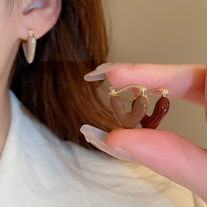 Detailed close-up of brown heart-shaped earrings with vintage gold metal finish