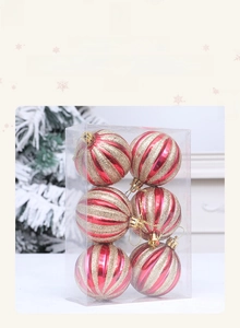 Close-up of red and white striped Christmas balls with gold glitter in a clear box