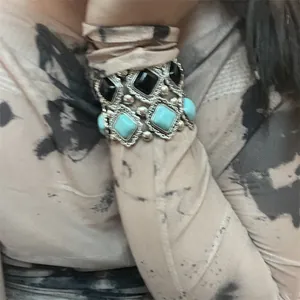 Détail d'une manchette bohème avec perles argentées et pierres carrées turquoise