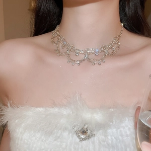 Detailed view of luxury gold necklace with sparkling crystals and elegant tassels on model
