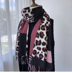 Detail of winter scarf showing leopard print patchwork and thick pink tassels