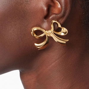 Polished 18K gold stainless steel bow earrings shown on a model for a stylish look