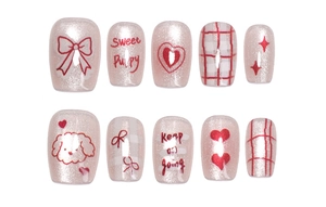 Detail of cat eye press-on nails featuring cute puppy, bow, and red heart patterns