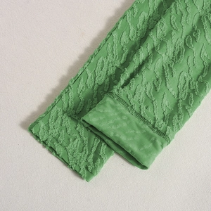 Detailansicht der grünen Ärmelmanschette mit 3D-Struktur und aufwendigem Jacquard-Muster