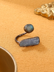 Detail of vintage bronze ring featuring labradortite and kyanite on velvet background